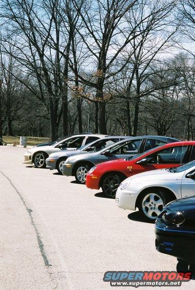 Several cars parked side-by-side, including a red Dodge Neon SRT-4 and a silver Dodge Neon SRT-4
