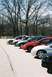 2004 Dodge SRT-4 - A line of cars, including two Dodge Neon SRT-4s, are parked in a lot with bare trees in the background.