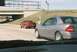 2004 Dodge SRT-4 - Two cars on the highway, a gray coupe in the foreground and a red sedan in the background.