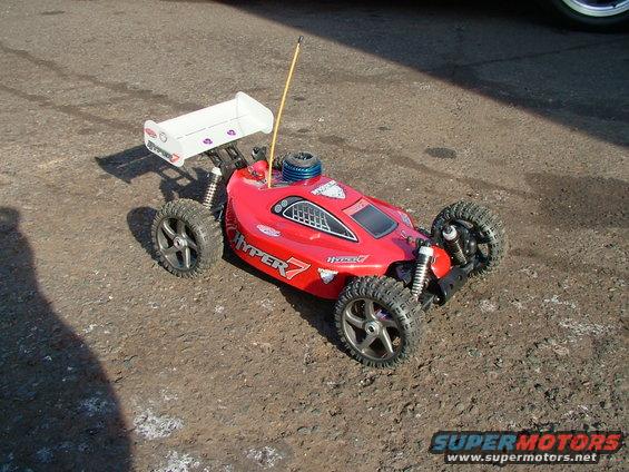 Red remote control buggy with white spoiler and 'HYPER 7' graphics