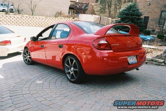 Red 2004 Dodge SRT-4 parked on a cobblestone driveway, another car to the left