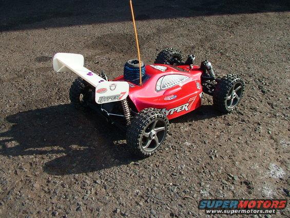 Red remote control buggy with white spoiler and 'HYPER 7' graphics
