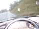 1994 Ford F-150 - View from inside a vehicle driving on a wet road, with a speed limit sign visible on the side of the road.