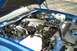 1990 Chevrolet Camaro - The engine bay of a 1990 Chevrolet Camaro, its V8 engine and blue exterior paint.