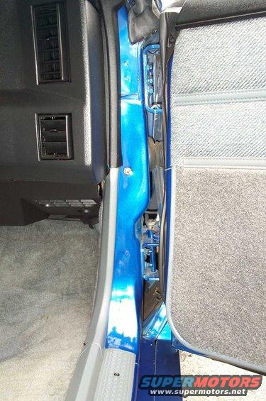 Close-up of a car's blue door jamb and interior paneling. Air vents visible on the dash