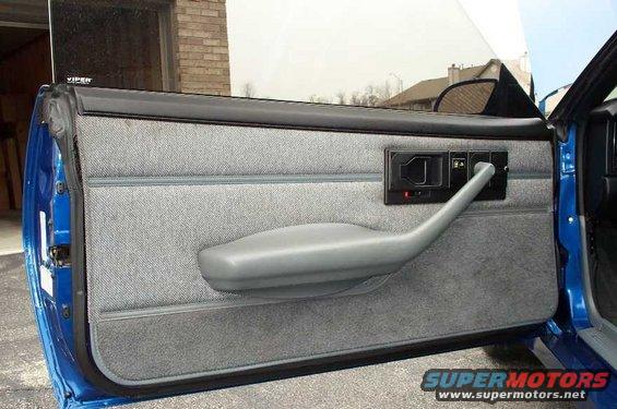 Interior of a blue car's door panel with gray fabric and a gray armrest