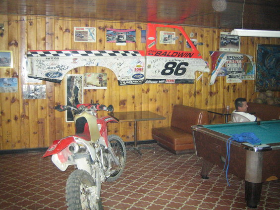 Ford truck body panel with Josh Baldwin 86 decals and checkered flag pattern hanging on a wood-paneled wall