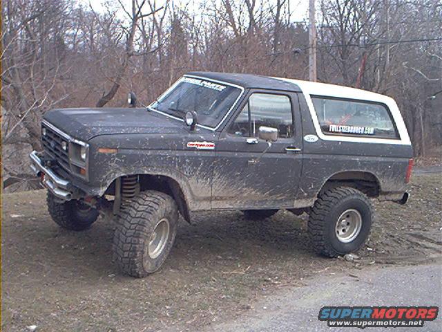 Muddy 1980 Ford Bronco with lifted suspension and off-road tires parked on dirt