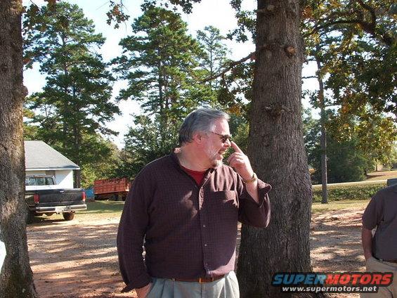 Man looking up and to the side, with a pickup truck and trailer in the background