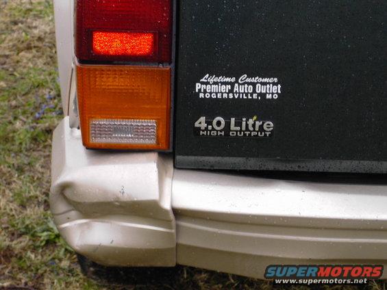 1993 Jeep Cherokee rear bumper with dent, taillight, and '4.0 Litre HIGH OUTPUT' badge