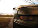 1996 Ford Probe - A car's front corner is covered in water droplets, with a rural landscape in the background.