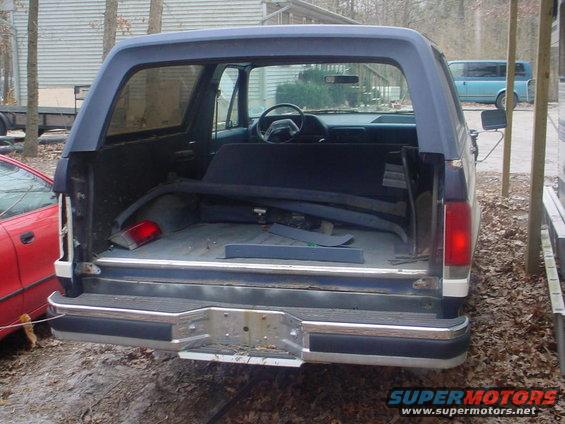 1988 Ford Bronco rear cargo area with seats folded down, steering wheel visible through open door