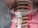 1995 Ford Thunderbird - Close-up of a rusty suspension strut and coil spring assembly, likely from a vehicle's wheel well.