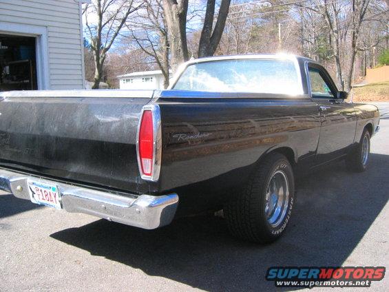 Black 1968 Ford Ranchero pickup truck, rear quarter view. Chrome bumper, red taillight, and 'Ranchero' script visible