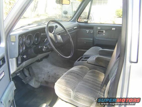 Gray fabric seats and dashboard of a truck interior. Visible are the steering wheel, gauges, and center console