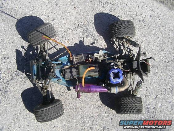 Top-down view of a remote control nitro car with a blue engine and purple exhaust pipe