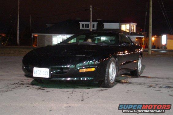 Black coupe with a white license plate reading AYCZ-093 parked at night