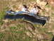 1966 Ford Ranchero - Car parts including bumper trim, bumper, and fender section laid out on grass.