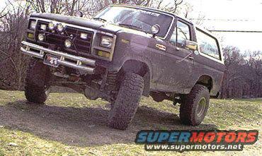 1980s Ford Bronco with lifted suspension and off-road tires on a dirt incline