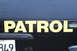 1991 Ford Crown Victoria - Rear view of a black patrol vehicle, yellow lettering and a California license plate.