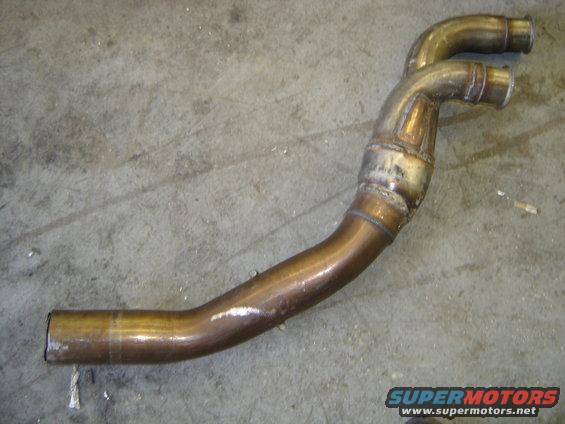 Exhaust pipe with two outlets, made of metal, on a concrete floor