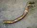 1997 Ford Ranger - A metal exhaust pipe with a Y-shaped configuration lies on a concrete surface.