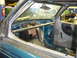 1997 Ford Ranger - The interior of a teal truck shows a roll cage and a large exhaust pipe, suggesting a custom modification.
