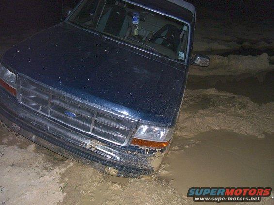 Dark blue 1992 Ford Bronco stuck in mud, front view