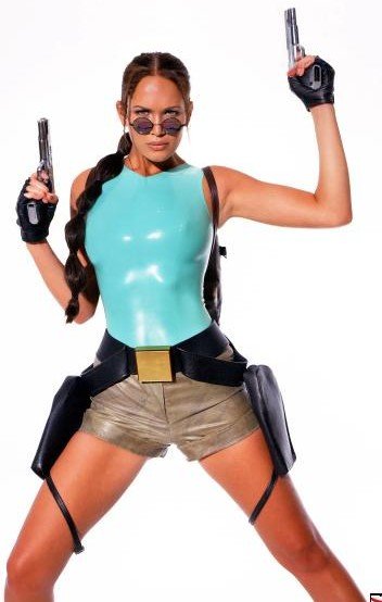 Woman dressed as Lara Croft, holding two pistols, wearing a teal tank top, tan shorts, and round sunglasses