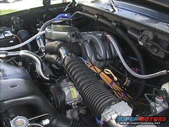 Engine bay of a 1992 Ford Bronco, showing the air intake, manifold, and various hoses and wires