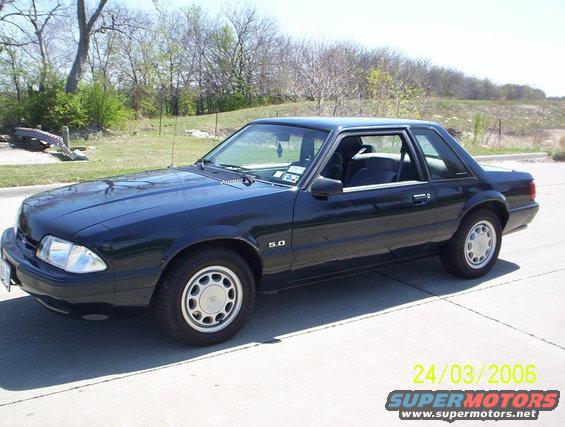 1991 Ford Mustang coupe, dark color, parked outside. The '5.0' badge is visible on the fender