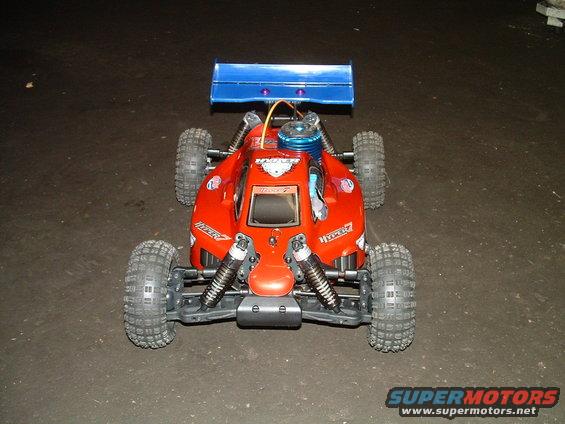 Red remote control buggy with blue spoiler and visible engine. Text 'HYPER' visible on sides