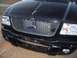 2003 Ford Ranger - The front grille and headlights of a black Ford truck are shown in this close-up photo.