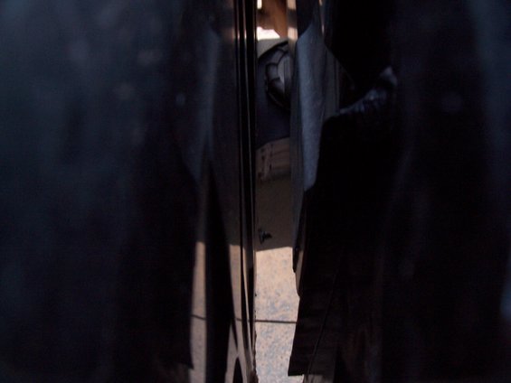 View into a dark vehicle interior, showing a seat and some paneling