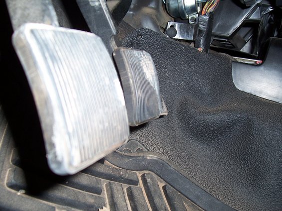 2003 Ford Ranger interior showing brake and accelerator pedals with textured rubber floor mat