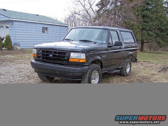 Black Ford Bronco parked in front of a garage