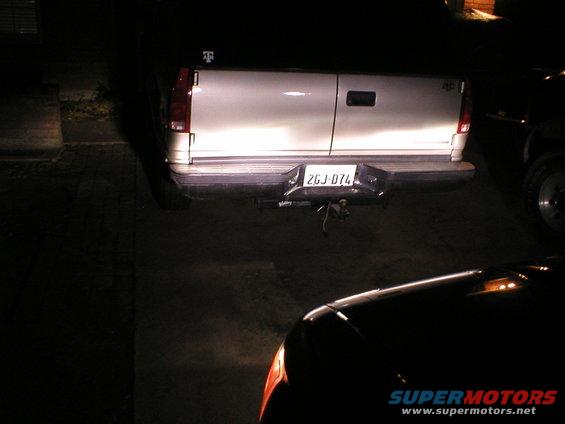Rear of white pickup truck with license plate 2GJ-074, another vehicle in foreground