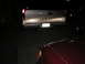 1996 Toyota 4Runner - Silver Chevrolet van's rear end is visible, with a license plate and a red car in front.