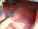 1967 Ford Ranchero - The interior floor of a vehicle is shown with red primer and some visible rust, indicating it may be undergoing restoration.
