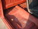 1967 Ford Ranchero - The interior floor of a vehicle is visible, showing the seat and door frame with red paint.