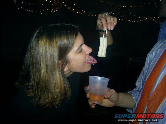 Woman with tongue piercing reaching for food held by a person
