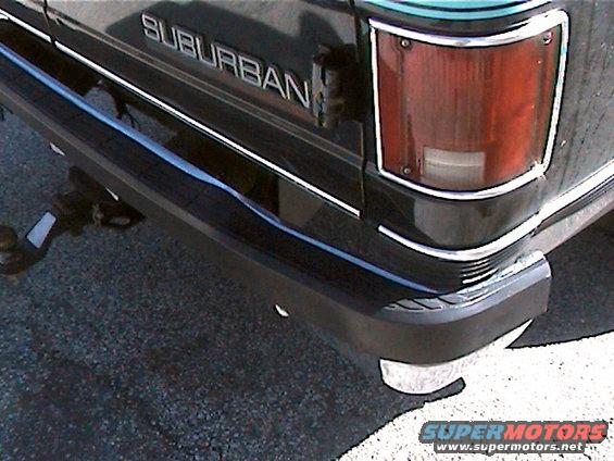 Rear bumper and taillight of a black Chevrolet Suburban with a trailer hitch