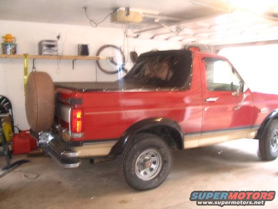 Red 1989 Ford Bronco rear view with spare tire
