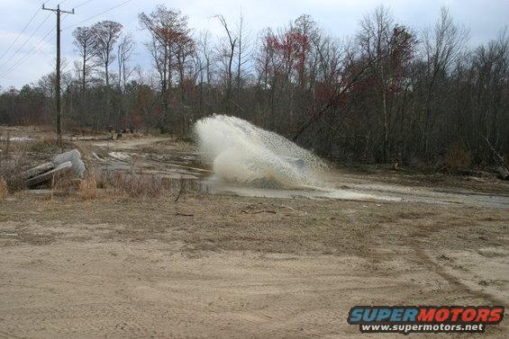 SUV driving through water splash