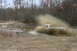 1989 Ford Bronco - A white pickup truck navigates a muddy obstacle, creating a large spray.