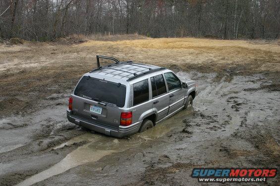 Silver SUV stuck in mud, rear view, license plate 5-9 LMTD