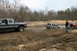 1989 Ford Bronco - A group of vehicles navigates a muddy off-road course, with one SUV deeply stuck in the mire.