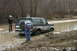 1989 Ford Bronco - A Ford Bronco is stuck in a muddy ditch with people observing the situation.