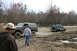 1989 Ford Bronco - Two Ford Broncos navigate a muddy off-road course, with one vehicle partially submerged in water.