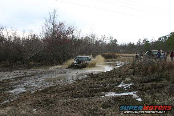 1989 Ford Bronco splashing through mud puddle, rear view